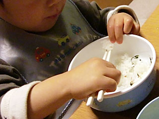 箸で食事中。
